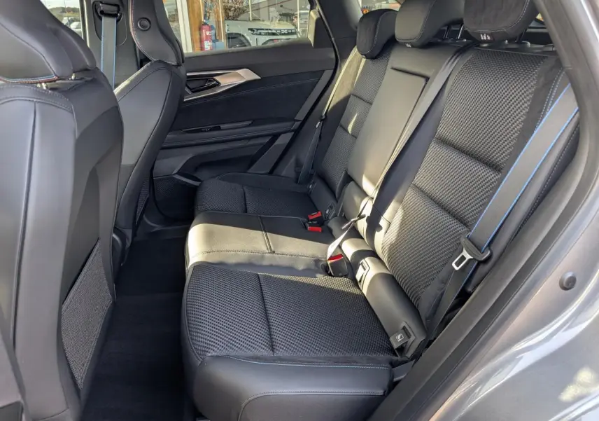 Vue latérale droite de la banquette arrière noire avec surpiqûres bleues du Renault Austral 2025 gris métallisé Esprit Alpine.