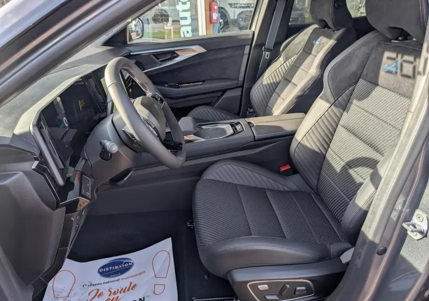 Intérieur côté conducteur du Renault Austral gris, sièges Alcantara avec surpiqûres tricolores et volant textile.