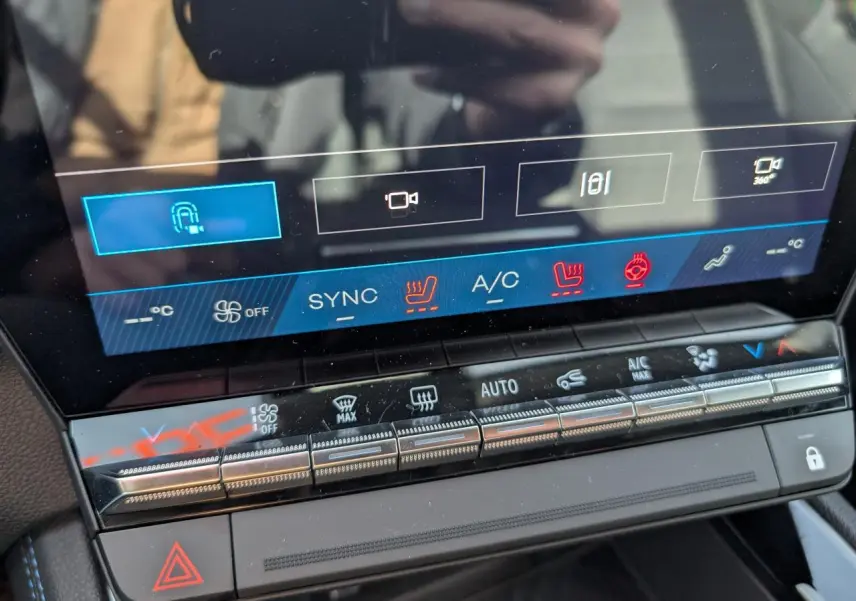 Vue rapprochée de la console centrale tactile du Renault Austral gris, montrant les commandes climatisation et assistances.