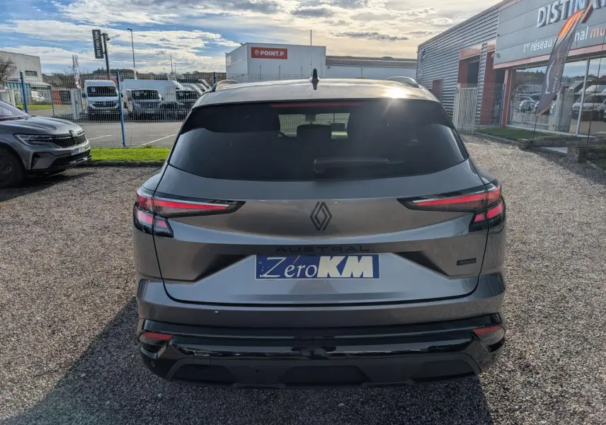 Vue arrière d’un Renault Austral gris métallisé avec feux LED fins et logo noir brillant sur un parking extérieur.