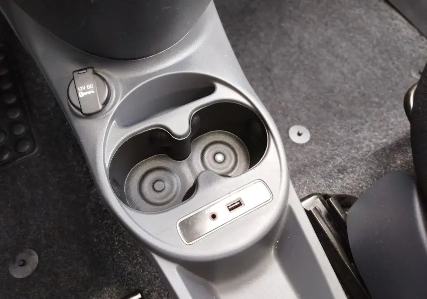 Vue rapprochée de la console centrale et prise 12V dans l'habitacle d'une Fiat 500 blanche de 2017.