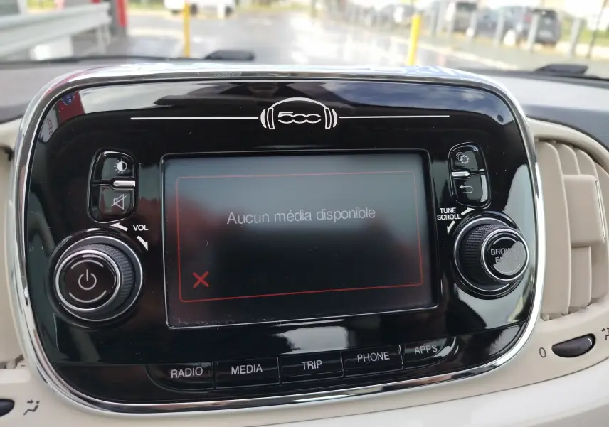 Vue rapprochée du tableau de bord de la Fiat 500 blanche, écran central tactile affichant "Aucun média disponible".