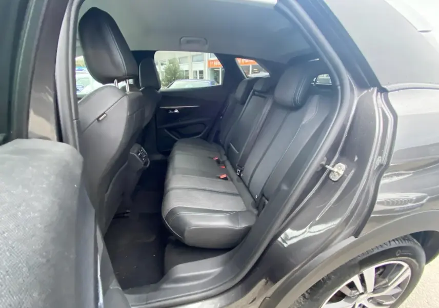 Vue côté droit arrière du Peugeot 3008 gris platinium 2021, montrant la banquette arrière en cuir noir et tissu.
