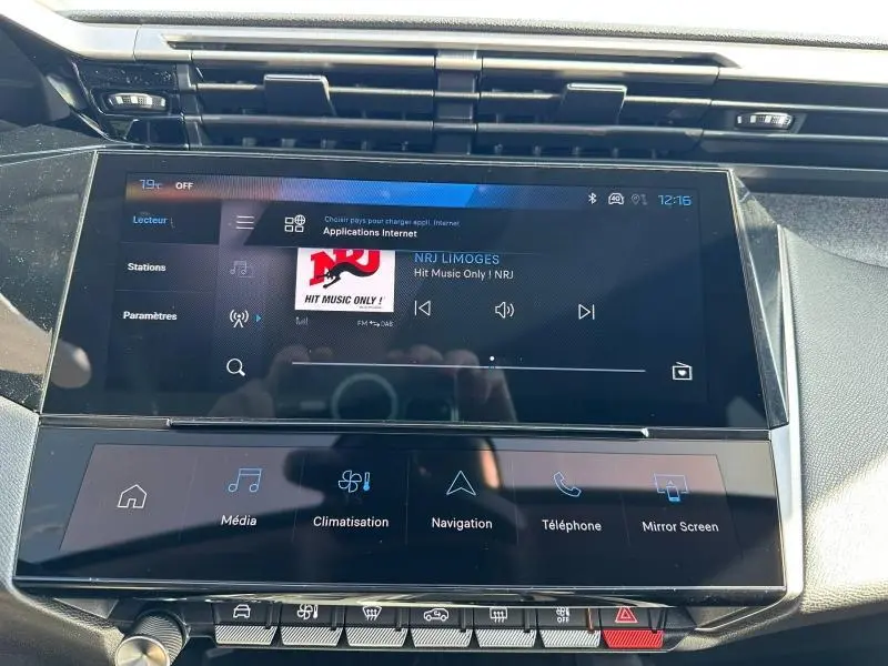 Vue rapprochée de l’écran tactile central multimédia de la Peugeot 308 2025 avec interface radio NRJ affichée.