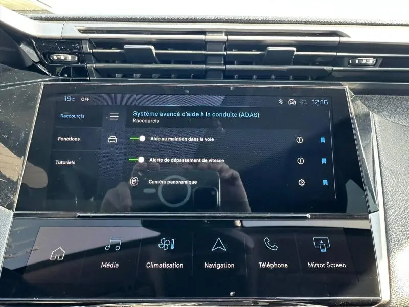 Écran tactile central de la Peugeot 308 2025 affichant les aides à la conduite et les raccourcis multimédia.