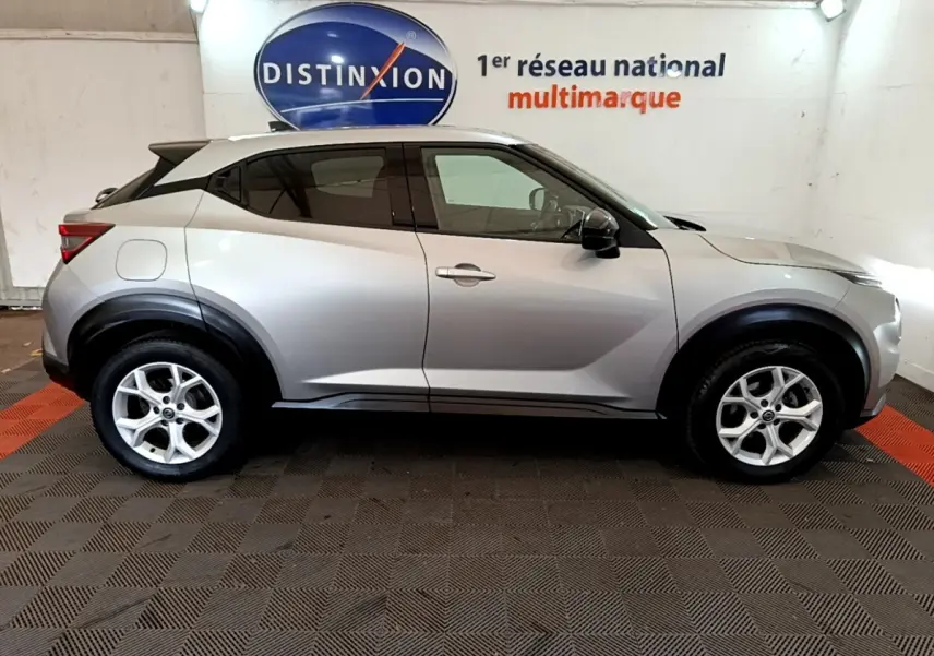 Vue latérale gauche d'un Nissan Juke gris clair 2022 avec jantes alliage et arches de roues noires.