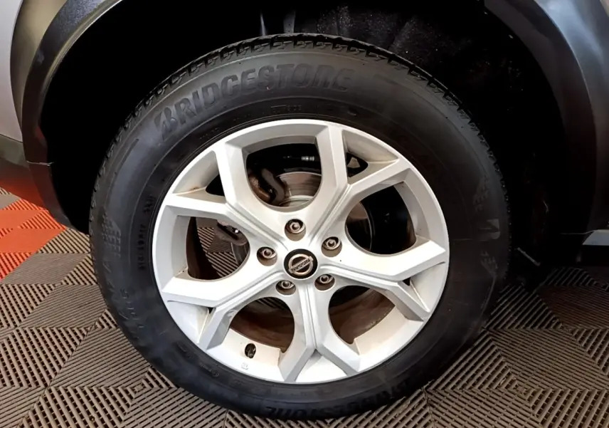 Gros plan sur la roue avant droite du Nissan Juke gris clair avec jante alliage et pneu Bridgestone.