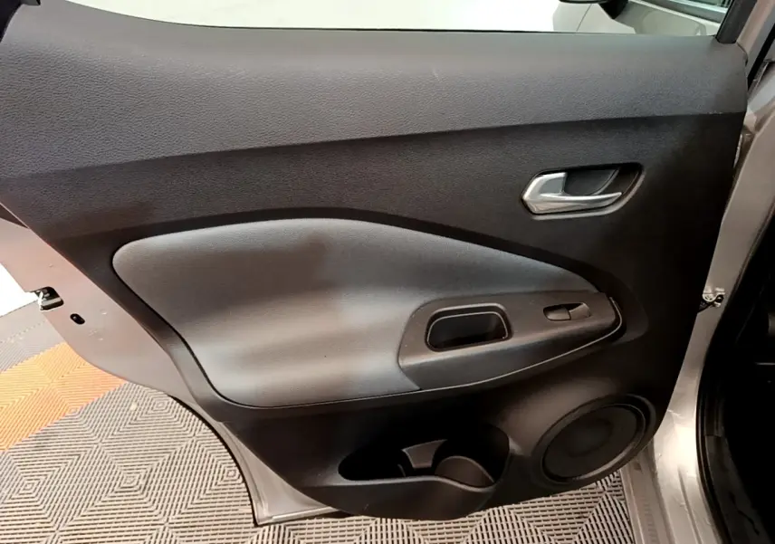 Vue intérieure de la porte avant droite gris clair du Nissan Juke 2022 avec poignée et haut-parleur intégrés.