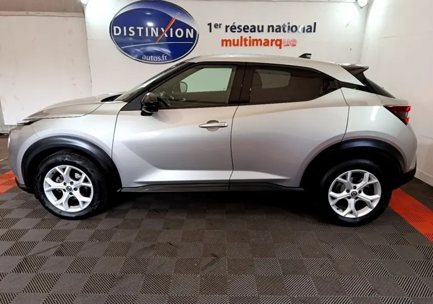 Profil droit du Nissan Juke Business+ 2022 gris clair, avec jantes alliage et rétroviseurs noirs électriques.