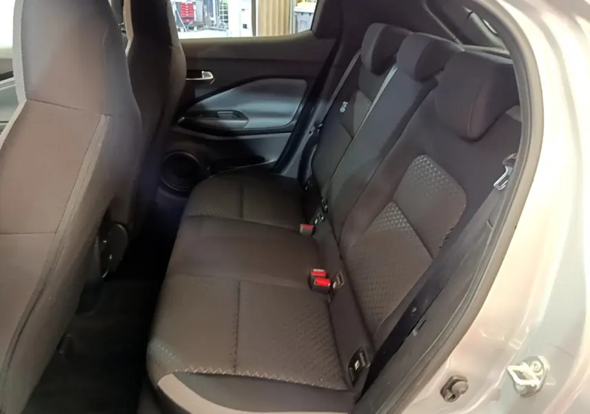Vue intérieure côté droit sur la banquette arrière noire du Nissan Juke gris clair, avec porte ouverte.