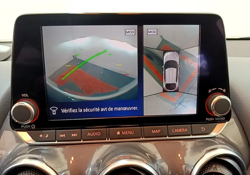 Écran tactile intérieur affichant la caméra 360° et l'aide au stationnement du Nissan Juke gris clair, vue de face.
