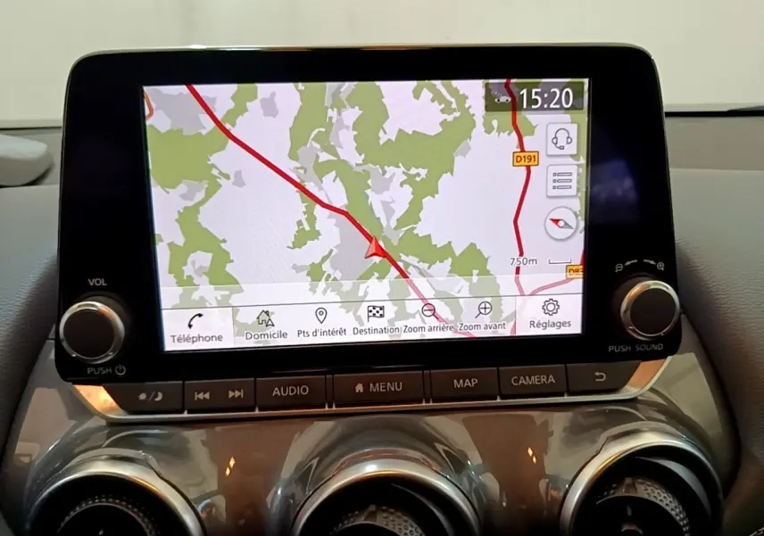 Écran tactile central du Nissan Juke 2022 affichant la navigation avec commandes audio et climatisation en dessous.