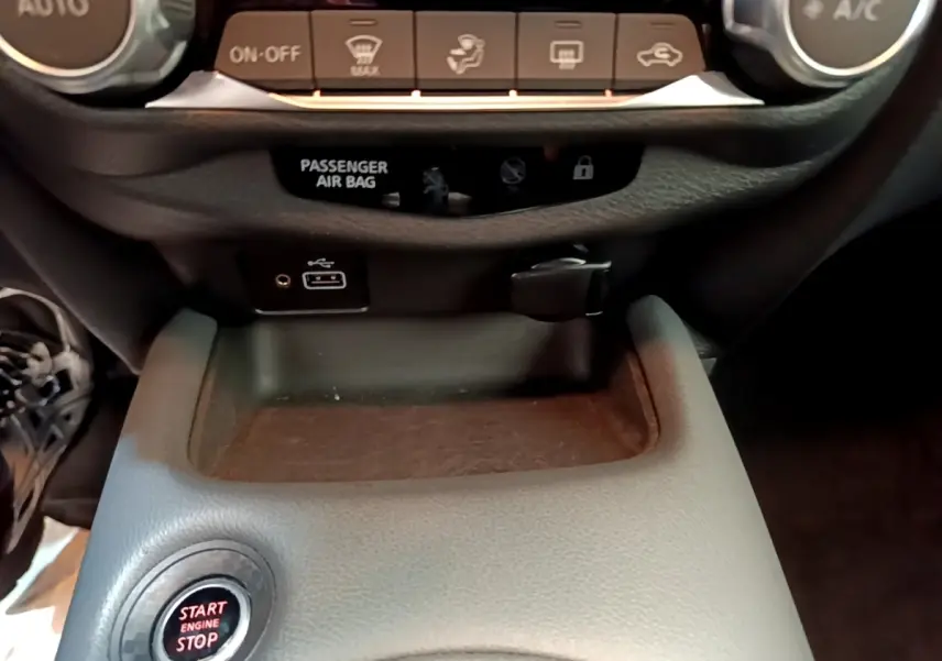 Détail de la console centrale du Nissan Juke gris clair 2022, avec bouton start/stop et ports USB visibles.