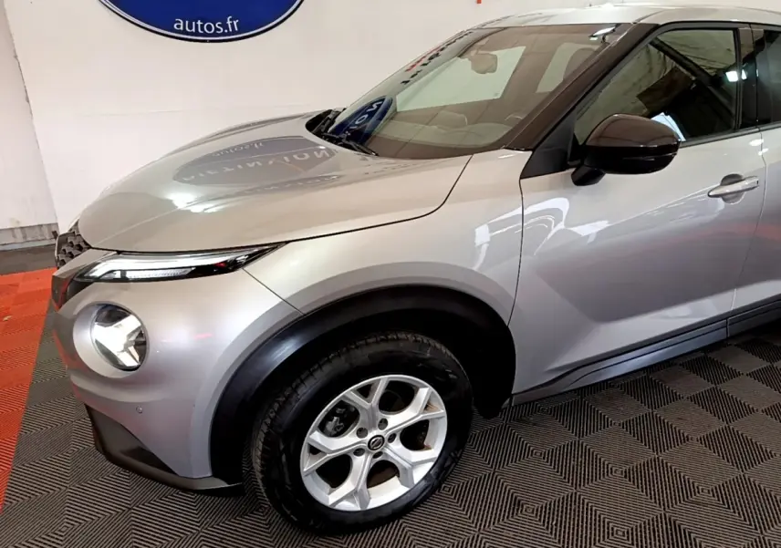Vue 3/4 avant droit d'un Nissan Juke Business+ gris clair avec jantes alliage et rétroviseurs noirs.