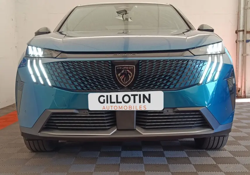 Vue frontale d'un Peugeot 3008 bleu avec phares LED distinctifs en forme de griffes et calandre texturée.