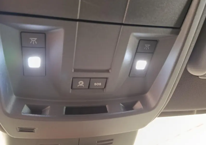 Vue en gros plan du plafonnier gris avec éclairage et boutons SOS du Peugeot 3008 1.2 Hybrid 136 GT 2025.