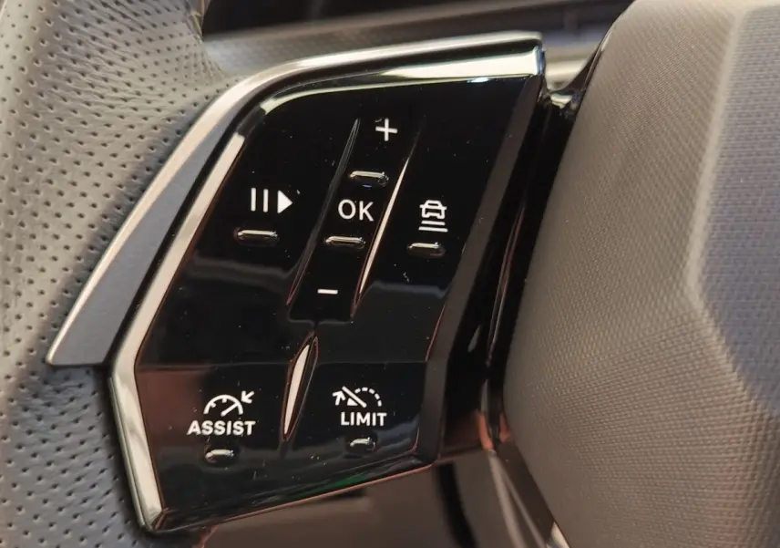 Gros plan sur les commandes multifonctions noires du volant cuir du Peugeot 3008 hybride bleu, côté gauche.