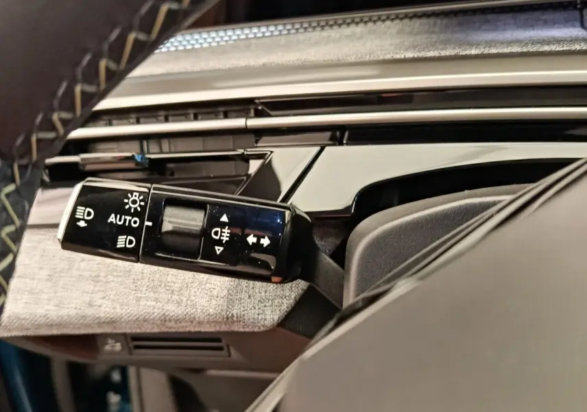 Gros plan sur la commande des feux et clignotants dans l’habitacle du Peugeot 3008 bleu 1.2 HYBRID 136 E-DCS6 GT.
