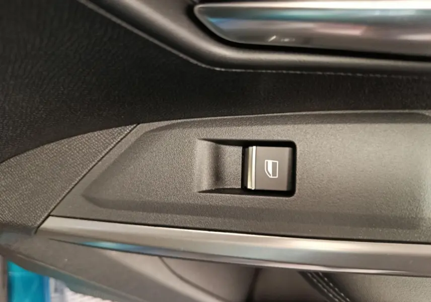 Gros plan sur le bouton de commande de vitre électrique côté conducteur du Peugeot 3008 bleu 2025.
