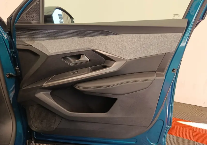 Vue rapprochée de la porte avant gauche bleu métallisé du Peugeot 3008 avec habillage tissu gris et cuir noir.