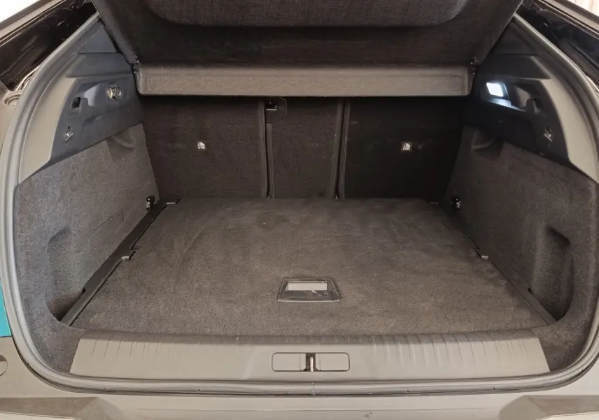 Coffre ouvert du Peugeot 3008 hybride bleu, vue arrière montrant un espace de chargement spacieux et tapis noir.