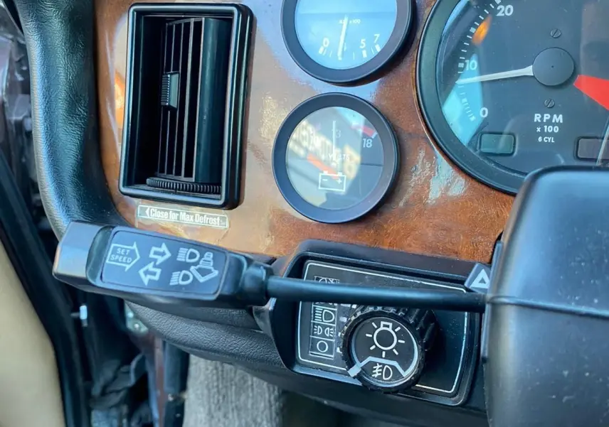 Gros plan sur le tableau de bord en bois marron de la Jaguar XJ6 Série 3 4.2 Sovereign de 1985, côté gauche.