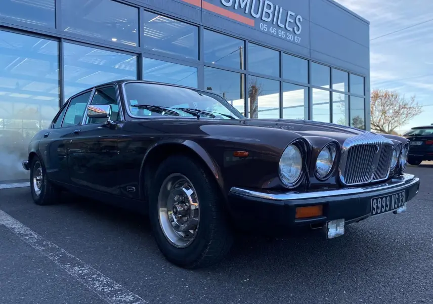 Jaguar XJ6 Série 3 4.2 Sovereign marron vue 3/4 avant droit, avec calandre chromée et phares ronds doubles visibles.