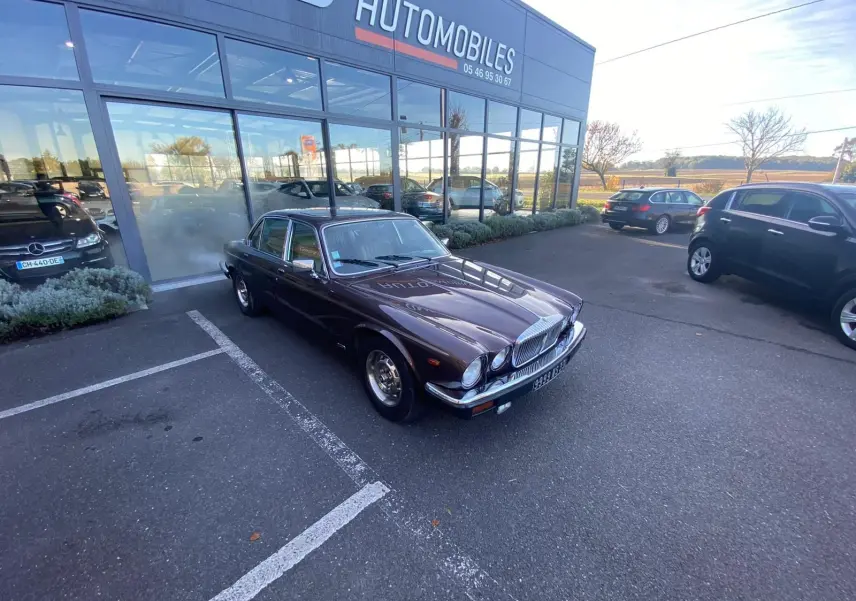 Jaguar XJ6 Série 3 4.2 Sovereign marron vue 3/4 avant droit, garée devant un showroom automobile.