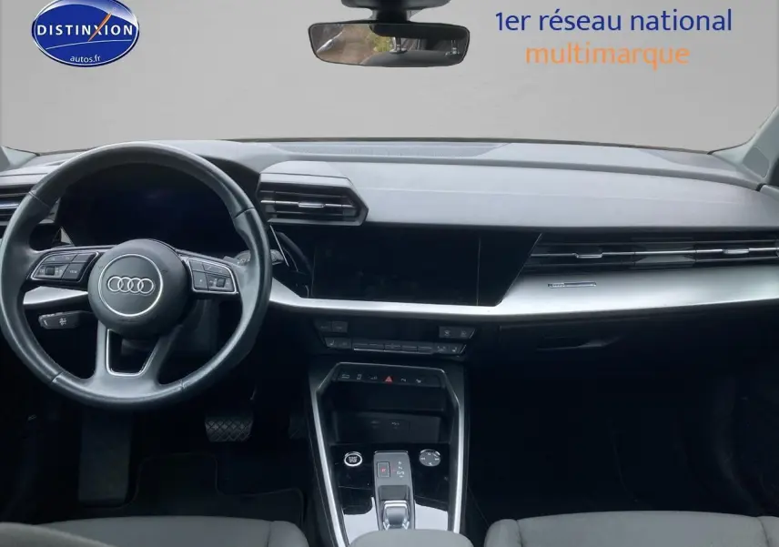 Vue intérieure avant de l'Audi A3 Sportback 40 TFSI noire, mettant en valeur le tableau de bord et le volant multifonction cuir.
