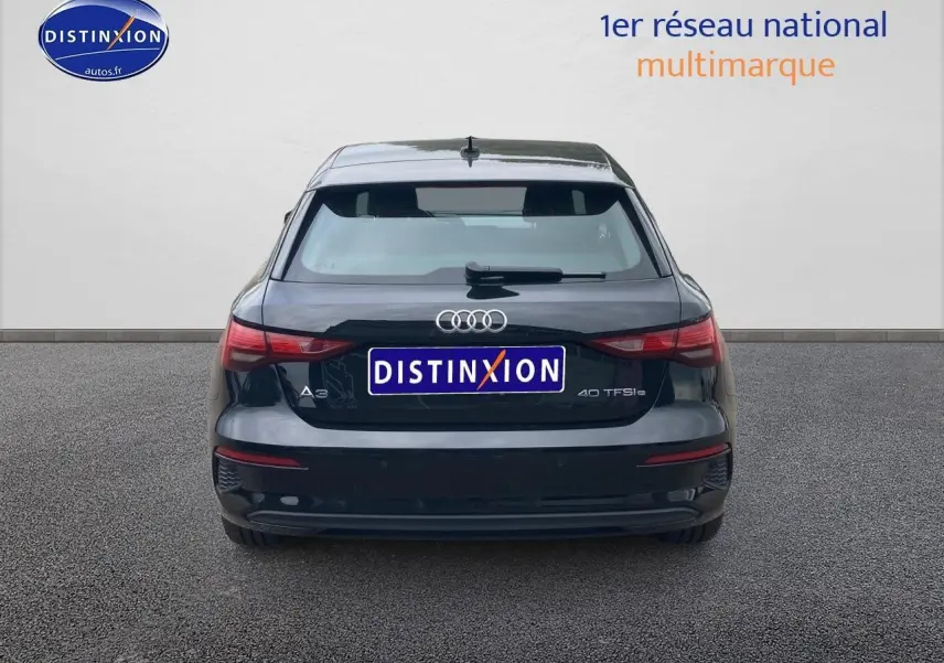 Vue arrière d'une Audi A3 Sportback 40 TFSI noire stationnée, avec logo et feux arrière visibles.