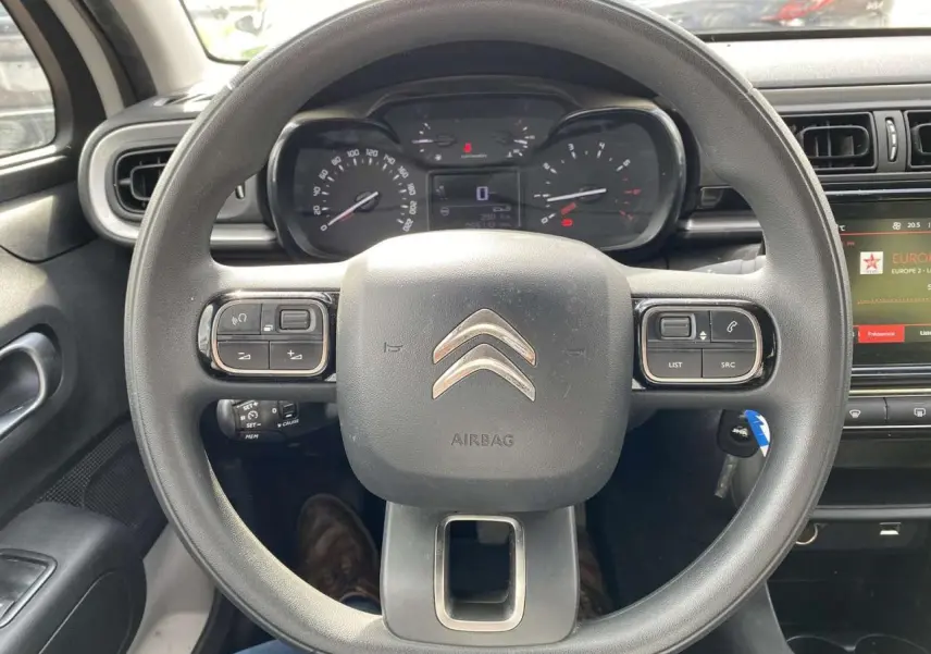 Vue rapprochée du volant noir de la Citroën C3 2019 avec commandes intégrées et tableau de bord numérique.