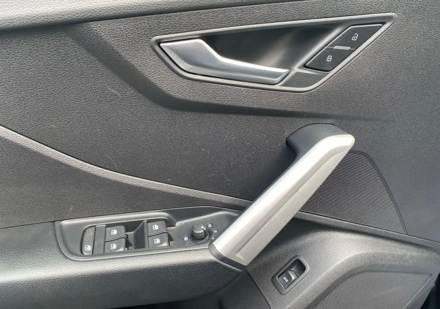 Poignée de porte intérieure côté gauche noire avec commandes de vitres et verrouillage sur Audi Q2 noir Mito 2023.