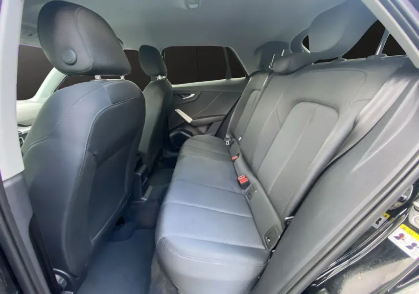 Vue intérieure côté droit des sièges arrière en tissu noir du SUV Audi Q2 noir Mito 2023.