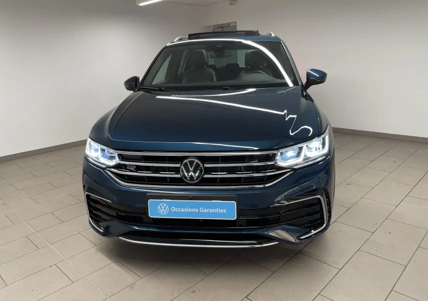 Volkswagen Tiguan 2024 Nightshade Blue vu de face avec phares allumés et calandre R-Line distinctive