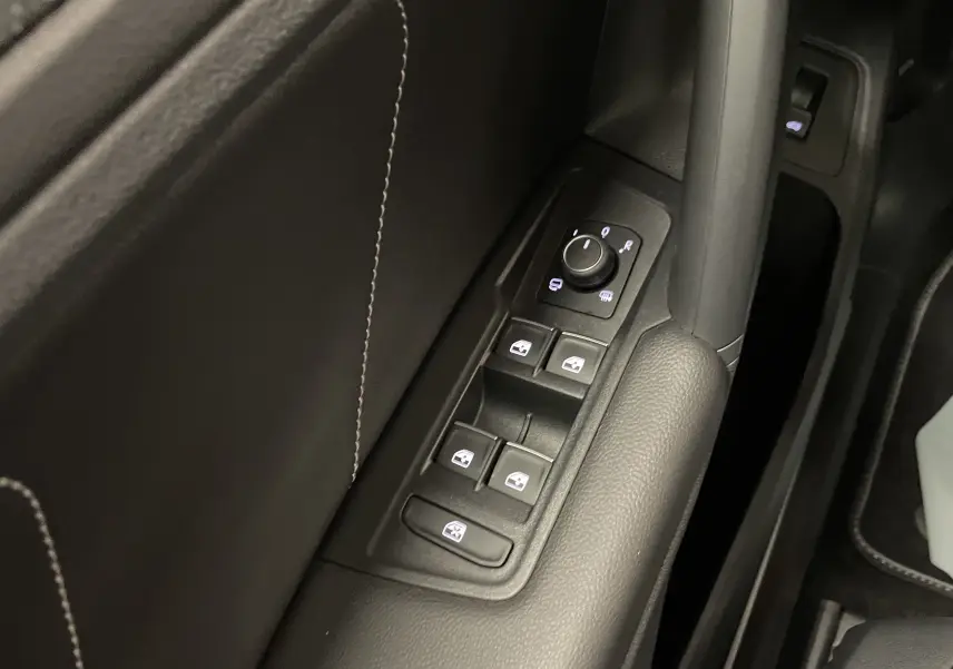 Gros plan sur les commandes des vitres et rétroviseurs sur la porte côté gauche du Volkswagen Tiguan 2024 finition R-Line.