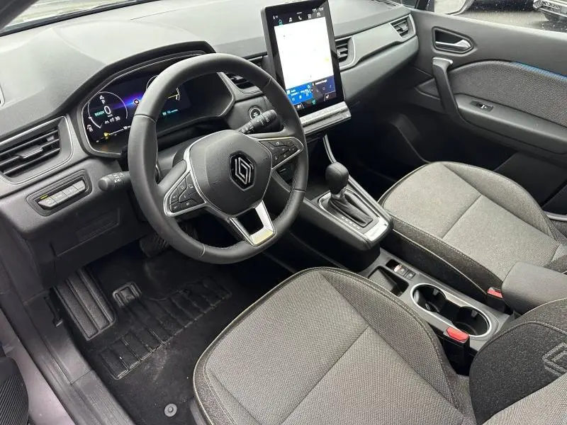 Vue intérieure côté conducteur du Renault Captur 2025 noir, avec volant multifonction et écran tactile vertical.