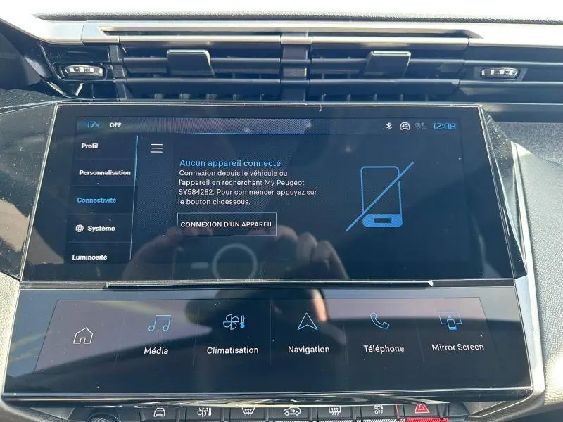 Vue rapprochée de l'écran tactile central noir du tableau de bord de la Peugeot 308 bleu, affichant le menu connectivité.