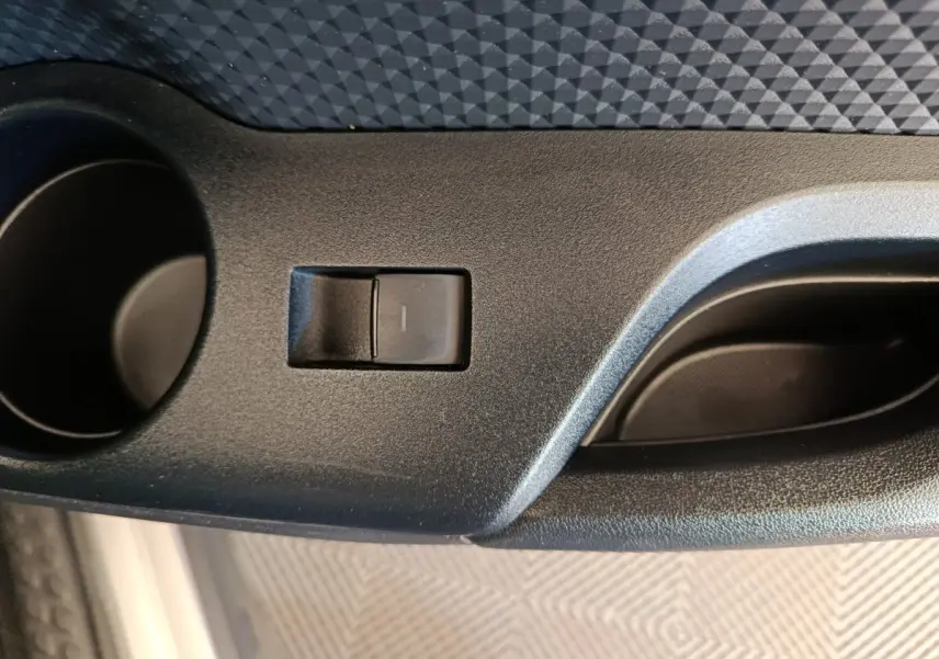 Gros plan sur le bouton de commande de la porte côté conducteur du Toyota C-HR gris clair 2022.