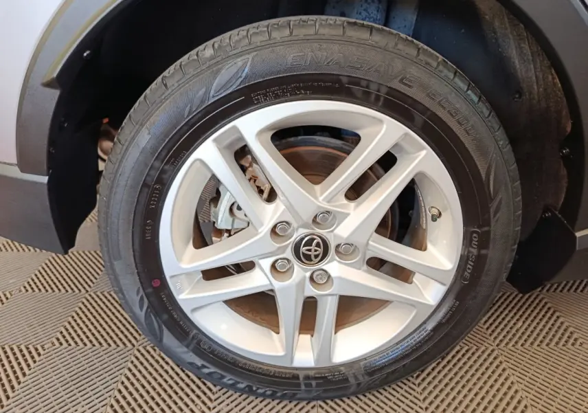 Gros plan sur la roue avant droite du Toyota C-HR gris clair, mettant en valeur la jante alliage à cinq branches.