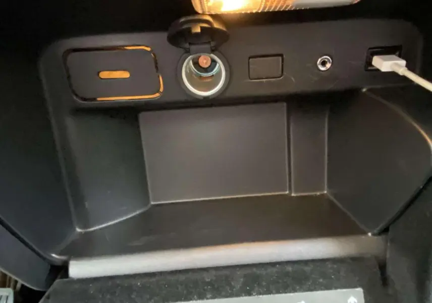 Prise allume-cigare, port jack et port USB dans le rangement central d'une Citroën C4 Spacetourer noire de 2019.