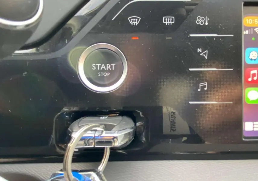 Gros plan sur le tableau de bord noir du Citroën C4 Spacetourer 2019, avec bouton start/stop et clé insérée.