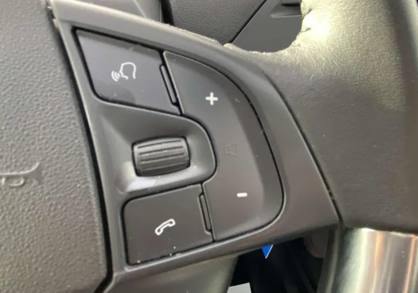 Gros plan sur les commandes vocales et téléphone au volant noir du Citroën C4 Spacetourer 2019 finition Feel Pack.