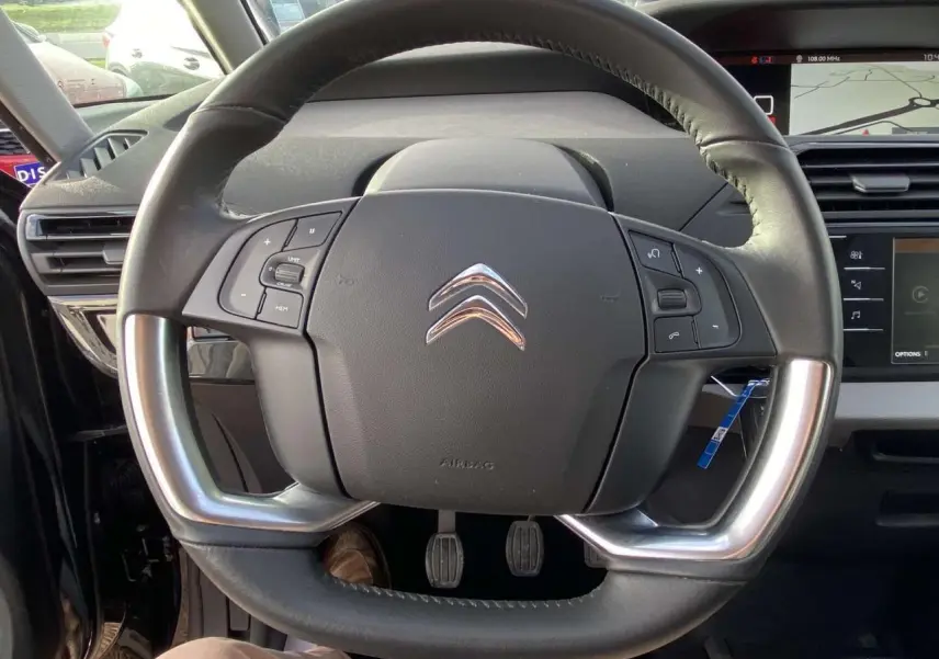 Volant cuir noir avec commandes intégrées sur Citroën C4 Spacetourer 2019, tableau de bord et écran tactile visibles en arrière-plan.