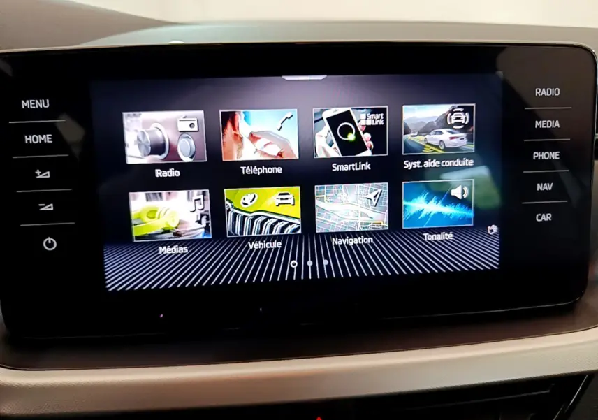 Écran tactile central du tableau de bord d’un Skoda Kamiq gris clair, affichant les options multimédia et navigation.