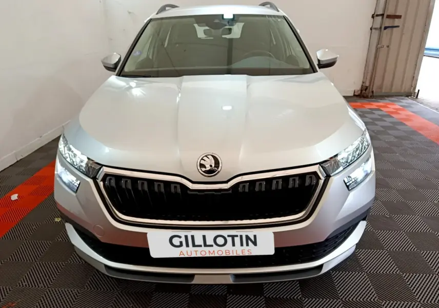 Vue frontale d'un Skoda Kamiq gris clair avec calandre noire et phares LED allumés en intérieur.