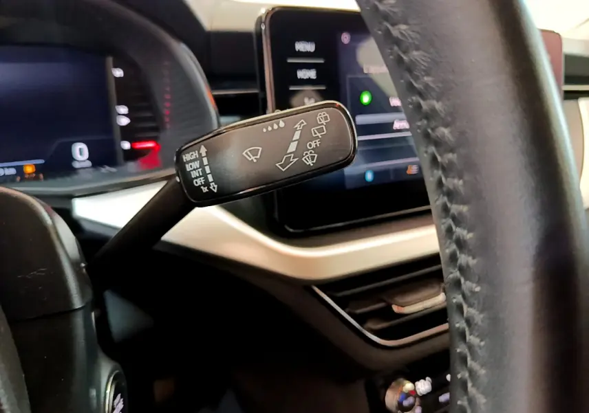 Gros plan sur la commande d'essuie-glace à gauche du volant cuir dans l'habitacle du Skoda Kamiq gris clair 2022.