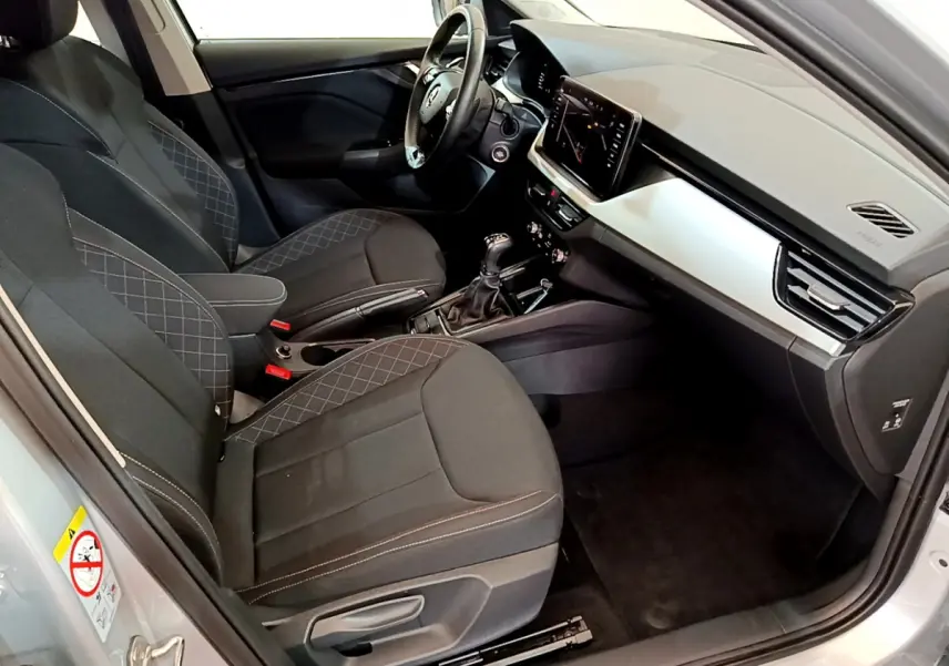 Intérieur côté conducteur du Skoda Kamiq gris clair 2022, sièges noirs avec surpiqûres et tableau de bord moderne.