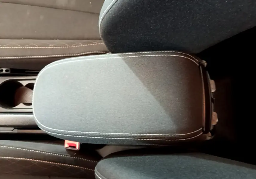 Vue rapprochée de l'accoudoir central noir avec surpiqûres blanches dans l'habitacle du Skoda Kamiq gris clair 2022.