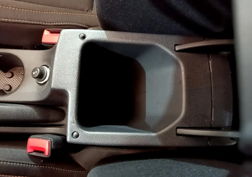 Vue rapprochée de la console centrale noire du Skoda Kamiq 2022 avec porte-gobelet et bouton 12V visible.