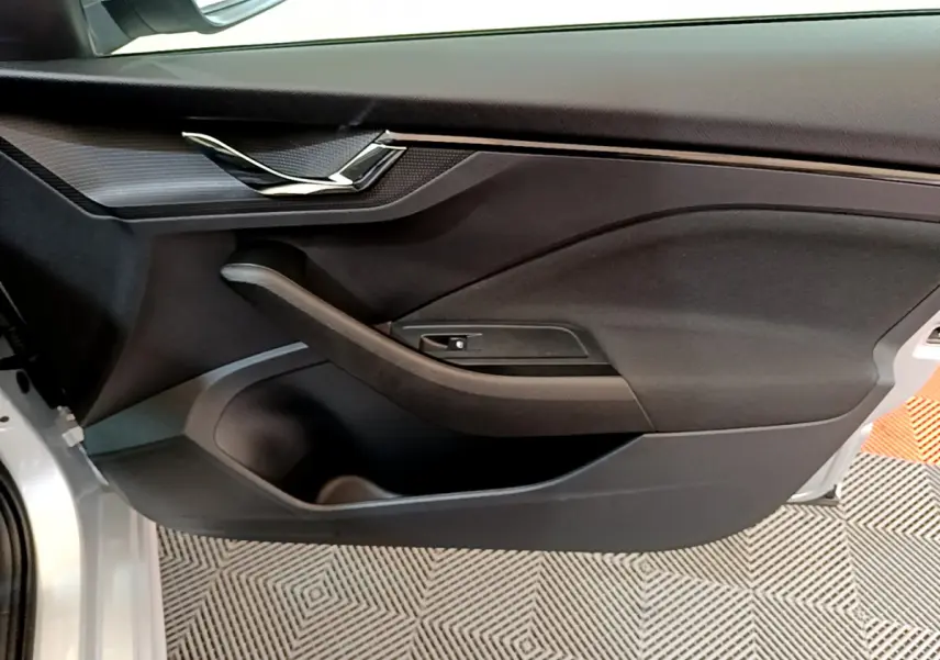 Vue rapprochée de la porte avant gauche gris clair du Skoda Kamiq 2022 avec poignée intégrée et garniture noire.